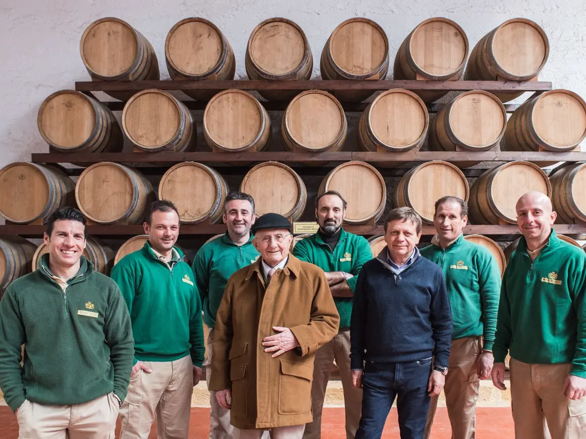 Martinez founders en team van wijndomein Martinez uit de Marsala regio in Sicilië boven gestapelde houten vaten