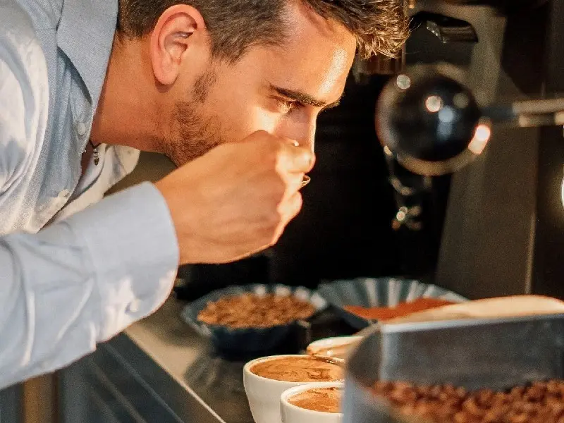 Rossini Caffè Daniele Allario huidige generatie koffiebranderij Piemonte ruikt aan koffiebonen bij espresso machines